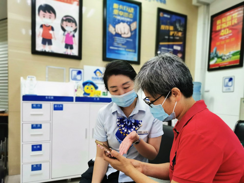 建行成都第六支行，大堂經(jīng)理為客戶介紹手機(jī)銀行&ldquo;大字&rdquo;模式